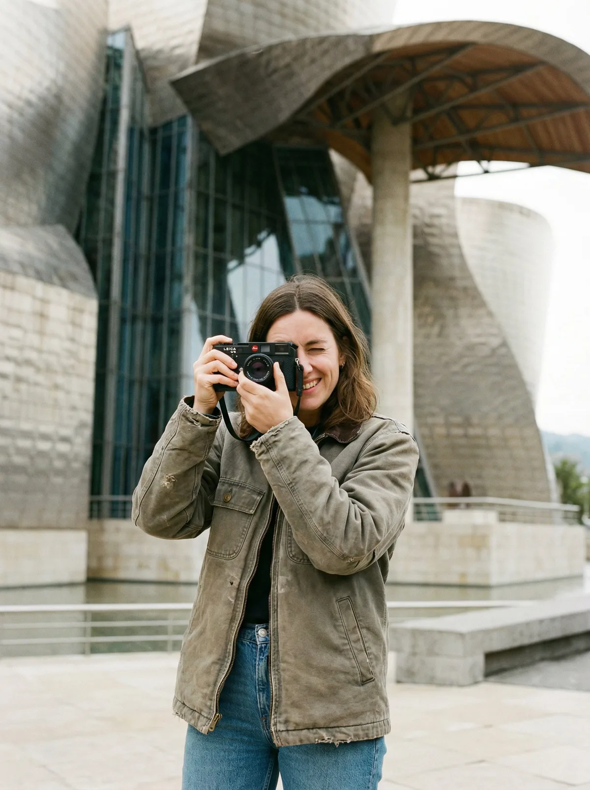 Женщина с камерой у современного музея